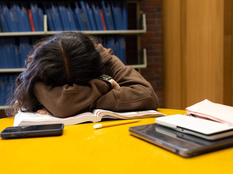 A student with her head down on home work.